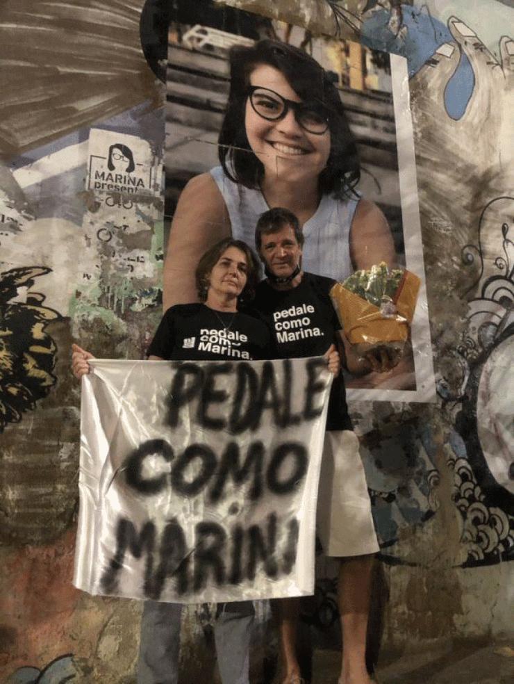 Claudia e Paulo, pais de Marina, homenageiam filha [foto atrás deles] no local onde ela foi atropelada e morta em São Paulo — Foto: Kleber Tomaz/g1