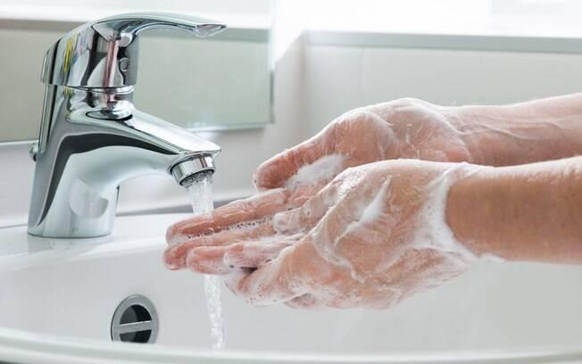 pessoa lavando as mãos em uma pia.