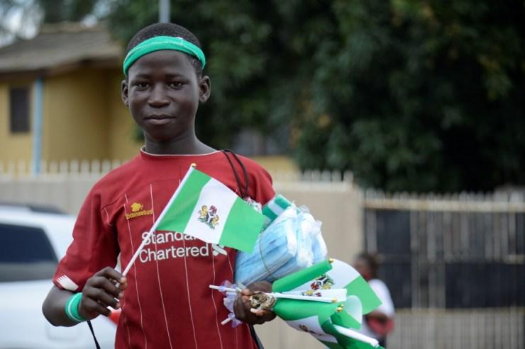 Menino nigeriano vende bandeiras durante a comemoração dos 60 anos da independência do país - Getty Images
