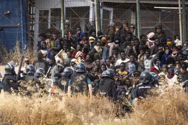 Grupo de migrantes é cercado por policiais espanhóis após conseguir pular cerca que divide o Marrocos de Melilla, cidade espanhola no norte da África, em 24 de junho de 2022.  — Foto: Javier Bernardo/ Associated Press