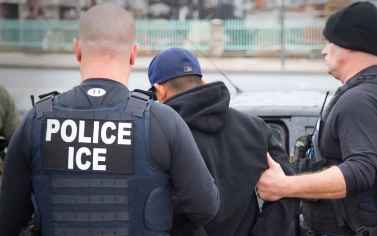 Em foto de 7 de fevereiro, agentes do Departamento de Imigração e Alfândega (ICE, na sigla em inglês) conduzem um imigrante ilegal preso em Los Angeles — Foto: Charles Reed/U.S. Immigration and Customs Enforcement via AP