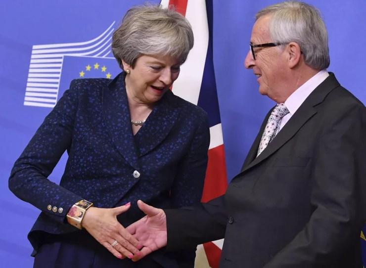 O presidente do Conselho Europeu, Jean-Claude Juncker, aperta a mão da primeira-ministra britânica, Theresa May, durante encontro em Bruxelas neste sábado (24)  — Foto: AP Photo/Geert Vanden Wijngaert