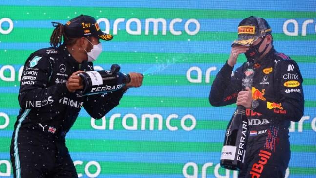 Hamilton joga champanhe em Verstappen no pódio da Espanha — Foto: Bryn Lennon/Getty Images