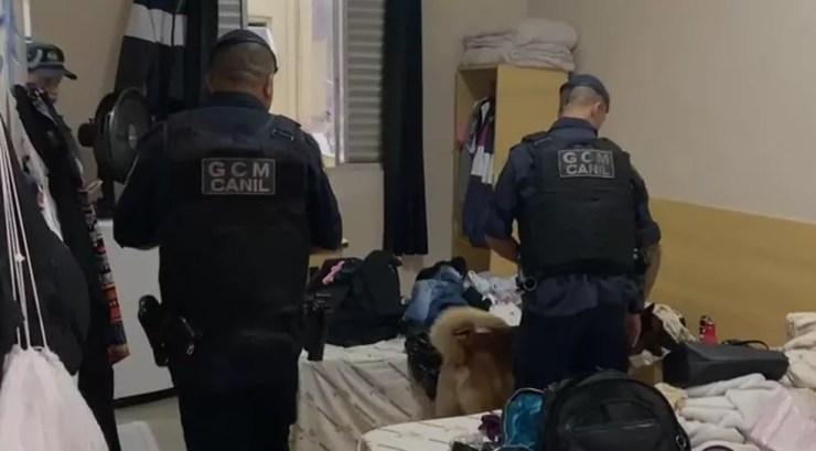 Guardas-civis usam cão farejador para tentar identificar drogas num dos imóveis onde estão sendo cumpridos os mandados de busca e apreensão — Foto: Divulgação/Polícia Civil