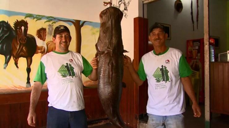 Alex e Castro posam ao lado do pintado de 60 quilos em Barretos, SP (Foto: Reprodução/EPTV)