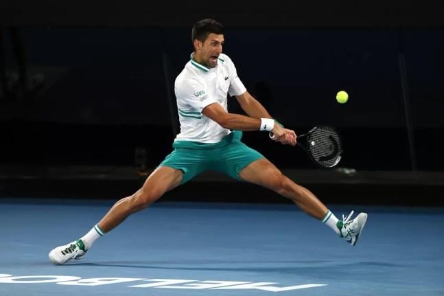 Novak Djokovic se estica todo para devolver para Aslan Karatsev — Foto: Getty Images