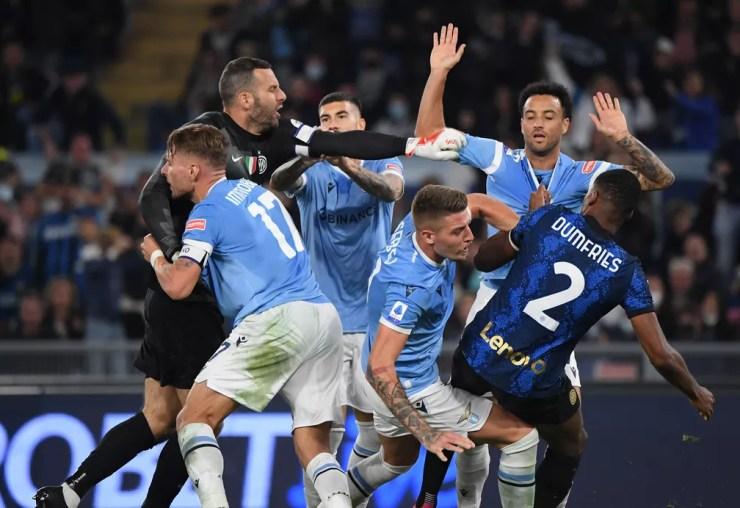 Felipe Anderson levanta os braços com a gola da camisa puxada por Dumfries em confusão depois de fazer gol da virada da Lazio sobre a Internazionale — Foto: REUTERS/Alberto Lingria