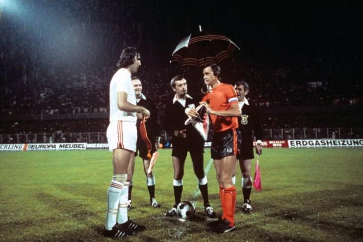 Zagueiro Anton Ondrus, capitão da Tchecoslováquia, e o craque Johan Cruyff, capitão da Holanda, antes da semifinal da Euro de 1976 — Foto: Peter Robinson - PA Images/Getty Images