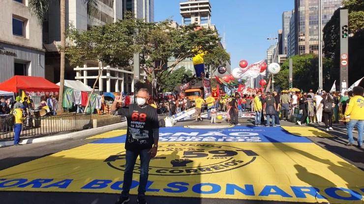 Faixa contra a privatização dos correios é colocada no chão da Av. Paulista, neste sábado (24) — Foto: Marina Pinhoni/G1