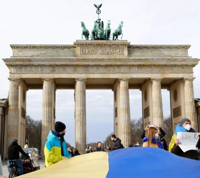 Manifestantes alemães erguem bandeira ucraniana em protesto contra guerra, em Berlim, capital da Alemanha, nesta quinta-feira (24)  — Foto: REUTERS/Michele Tantussi