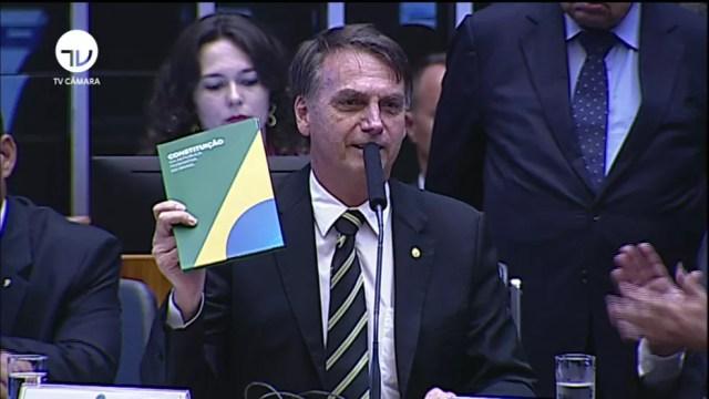 Bolsonaro mostra a Constituição durante cerimônia no Congresso — Foto: Reprodução/TV Câmara
