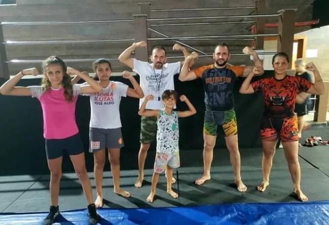 Brenda Games posa ao lado da família com o treinador de wrestling Daniel Piratiev — Foto: Arquivo Pessoal