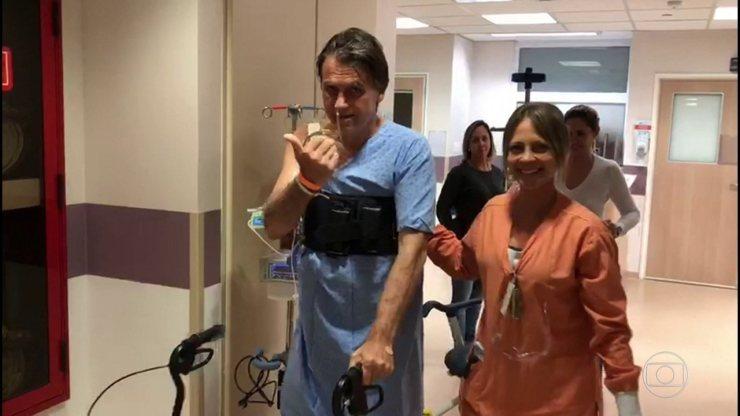 Jair Bolsonaro caminha em corredor de hospital