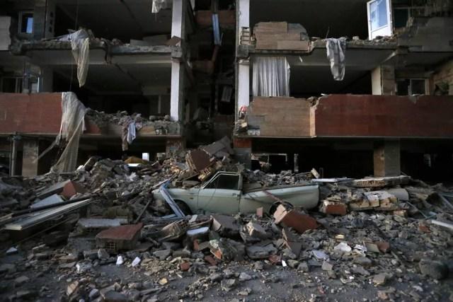 Carro destruído sobre destroços de prédio após terremoto na cidade de Sarpol-e-Zahab, no Irã (Foto: ouria Pakizeh/ISNA/AP)