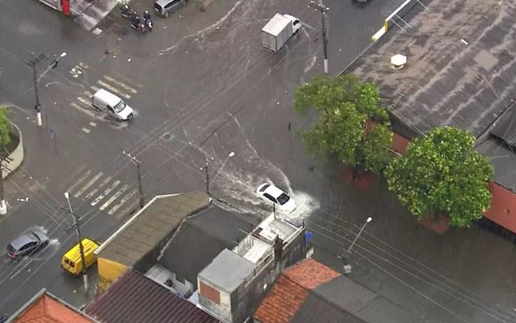 Carro passa por rua alagada na Zona Sul de São Paulo — Foto: TV Globo/Reprodução