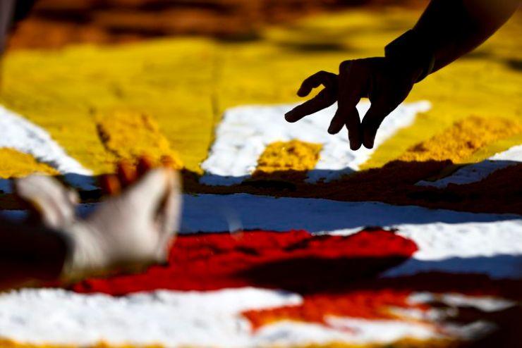 Fiéis confeccionam os tradicionais tapetes de serragem durante a Festa de Corpus Christi de Brasília, que retorna à Esplanada dos Ministérios após 2 anos de celebrações reduzidas por conta da pandemia.