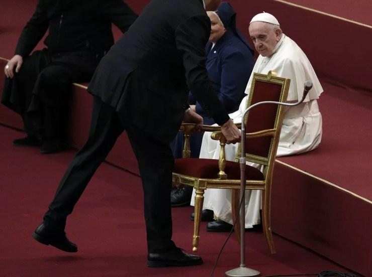 O Papa decidiu sentar em um dos degraus do palco do auditório do Vaticano, ao invés da cadeira. — Foto: AP Photo/Gregorio Borgia