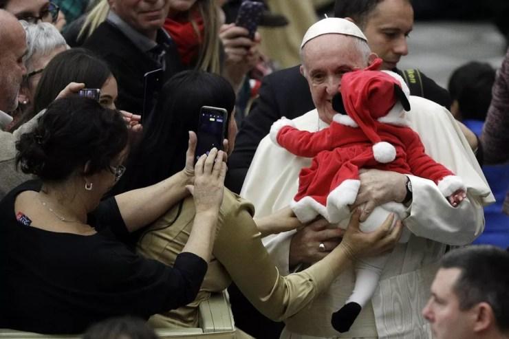 Papa Francisco carrega uma das crianças no domingo (16). — Foto: AP Photo/Gregorio Borgia