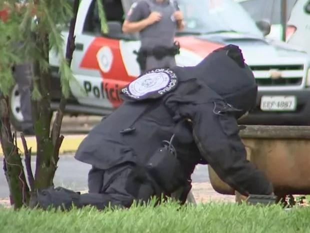 Policial enterra bomba em gramado na praça da cidade (Foto: Reprodução/ TV TEM)