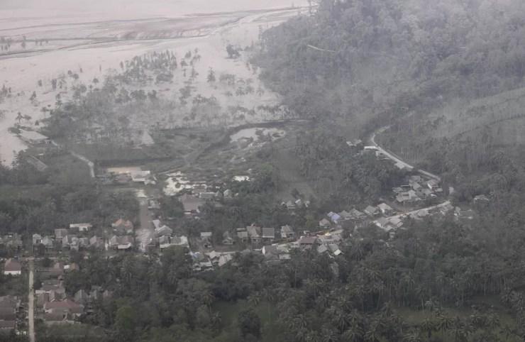 Foto mostra aldeia coberta por cinzas da erupção do Monte Semeru, no distrito de Lumajang, província de Java Oriental, na Indonésia, neste domingo (5).  — Foto: Trisnadi/AP