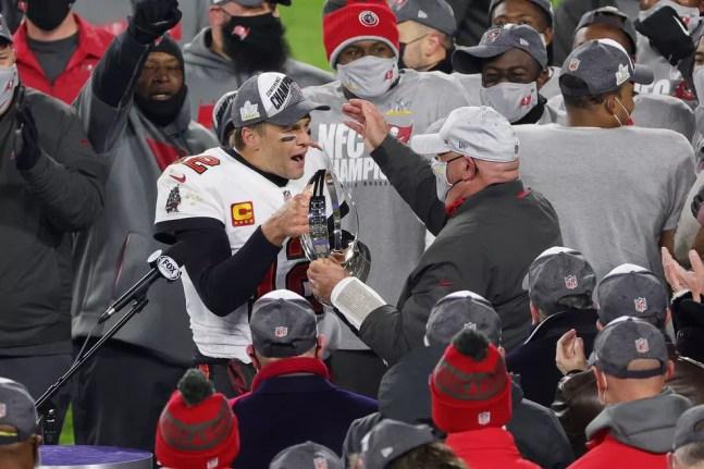Tom Brady entrega o troféu de campeão da NFC ao treinador Bruce Arians — Foto: Stacy Revere/Getty Images