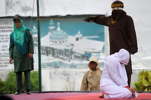 Jovem foi punida nesta segunda-feira (17) a 23 chibatadas porque foi vista muito próxima de seu namorado em Banda Aceh (Foto: Chaideer Mahyuddin/AFP)