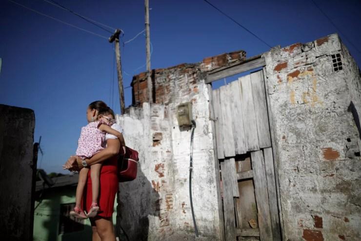 Gleyse Kelly da Silva, de 28, segura a filha de dois anos Maria Giovanna, na casa onde moram no Recife — Foto: Ueslei Marcelino/Reuters