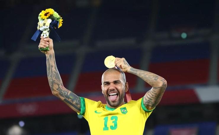 Daniel Alves põe a medalha de ouro acima da cabeça na comemoração da conquista das Olimpíadas de Tóquio — Foto: REUTERS/Thomas Peter