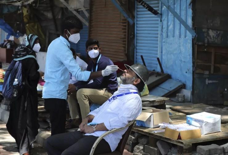 Trabalhador de saúde usa swab nasal para coletar amostras de um homem para um teste de Covid-19 em Bengaluru, na Índia, em 2 de junho de 2021 — Foto: Aijaz Rahi/AP