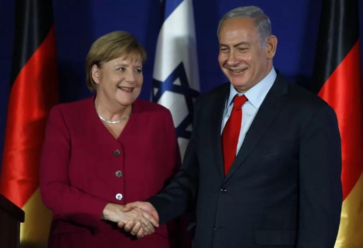 Chanceler alemã Angela Merkel e primeiro-ministro israelense Benjamin Netanyahu apertam as mãos durante coletiva de imprensa nesta quinta-feira (4) em Jerusalém — Foto: Menahem Kahana/ AFP