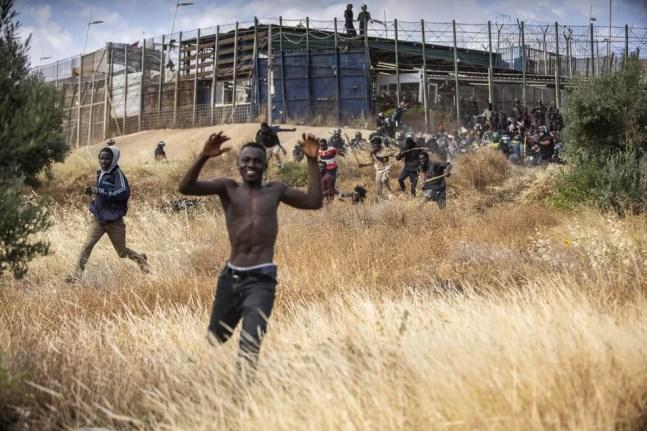 Homem celebra ao conseguir entrar em território espanhol após cerca de 2.000 migrantes pularem a cerca que divide o Marrocos de Melilla, cidade espanhola no norte da África, em 24 de junho de 2022. — Foto: AP