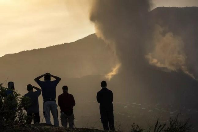 Moradores olham de uma colina enquanto a lava flui do vulcão em erupção na ilha de La Palma , na Espanha, em 24 de setembro de 2021. O vulcão nas Ilhas Canárias, um território espanhola no Oceano Atlântico, continua a produzir explosões e a expelir lava cinco dias após entrar em atividade. — Foto: Emilio Morenatti/AP