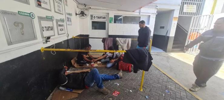 Motoboys sentam no chão para comer após bancos terem sido retirados do Hub Pinheiros — Foto: Bárbara Muniz Vieira/g1