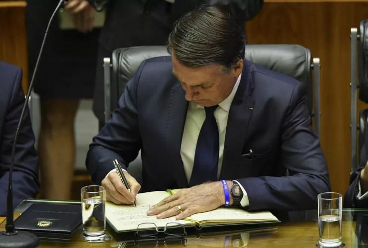Bolsonaro assina o livro com o termo de posse dos presidentes da República — Foto: Nelson Almeida/AFP