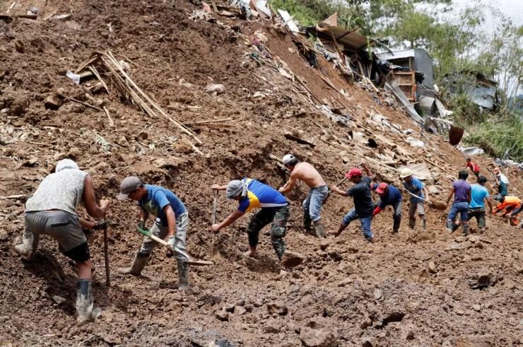 Socorristas trabalham nesta segunda-feira (17) em mina soterrada durante busca por mineiros que ficaram presos no local após a passagem do tufão Mangkhut — Foto: Erik De Castro/Reuters