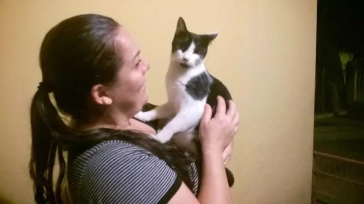 Protetora Katiusca Angelica Lopes com um dos 53 gatos que cuida (Foto: Francine Galdino/G1)