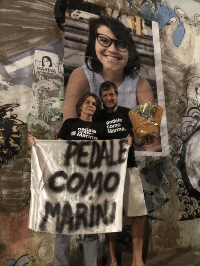 Claudia e Paulo Harkot, pais de Marina, homenageiam filha [foto atrás deles] no local onde ela foi atropelada e morta em São Paulo — Foto: Kleber Tomaz/g1