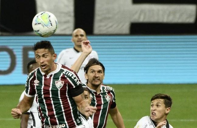 Fábio Santos, ao fundo, observa a jogada — Foto: Marcos Ribolli