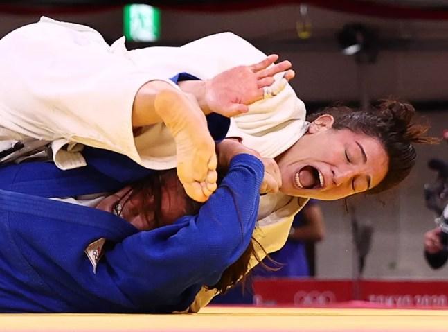 Mayra Aguiar (de branco) vibra após derrubar a holandesa Guusje Steenhuis (de azul) — Foto: REUTERS/Sergio Perez