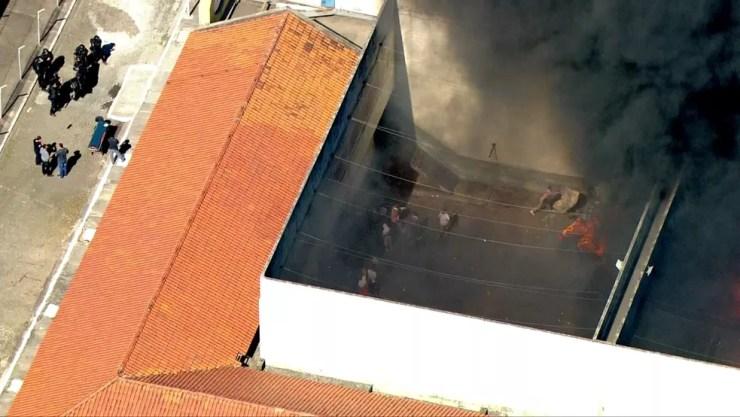 Homem joga colchão em direção ao fogo no cadeião de Pinheiros (Foto: Reprodução/TV Globo)