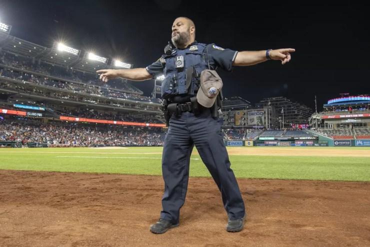 Policial organiza torcedores em estádio de beisebol, em Washington, após tiroteio do lado de fora em 17 de julho de 2021 — Foto: Brad Mills/ USA Today Sports/Reuters