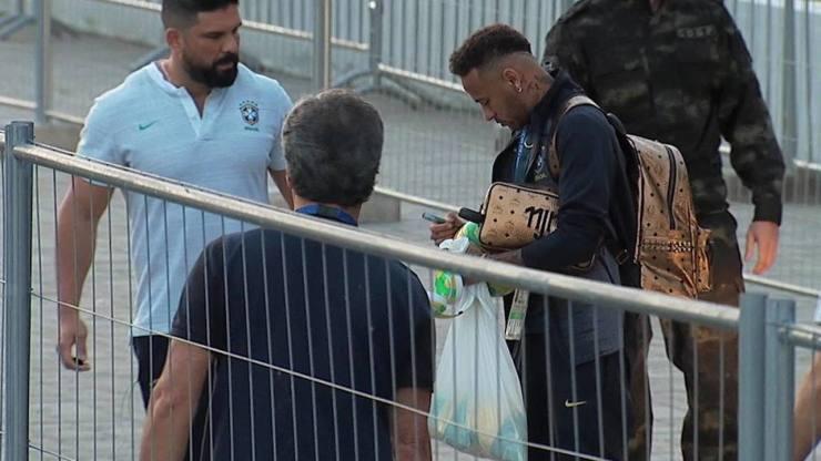 Neymar autografa bola de jovem torcedor no desembarque da seleção em hotel em Kazan