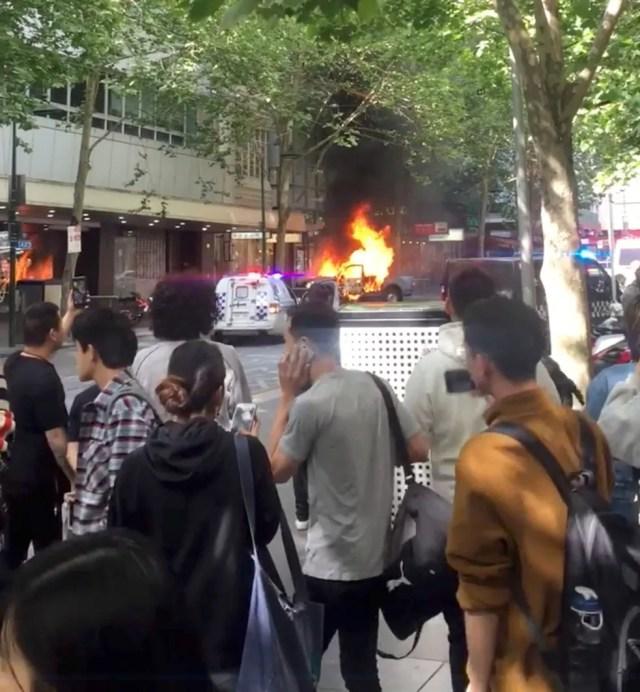 Carro em chamas é visto perto do Bourke Street Mall, em Melbourne, Austrália, nesta sexta-feira (9). Imagem foi tirada do vídeo divulgado nas mídias sociais  — Foto: Will Mitchell/via Reuters 
