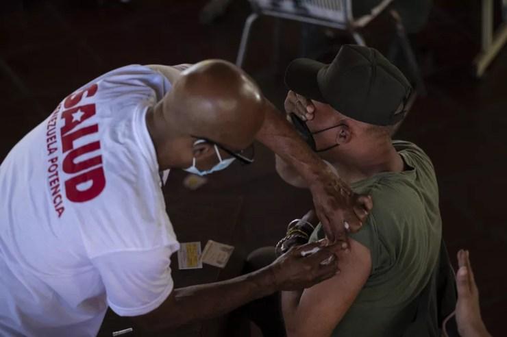 Soldado venezuelano reage ao receber a vacina cubana Abdala contra a Covid-19 em uma campanha de vacinação em massa em Caracas, na Venezuela, no dia 30 de junho. — Foto: Yuri Cortez/AFP
