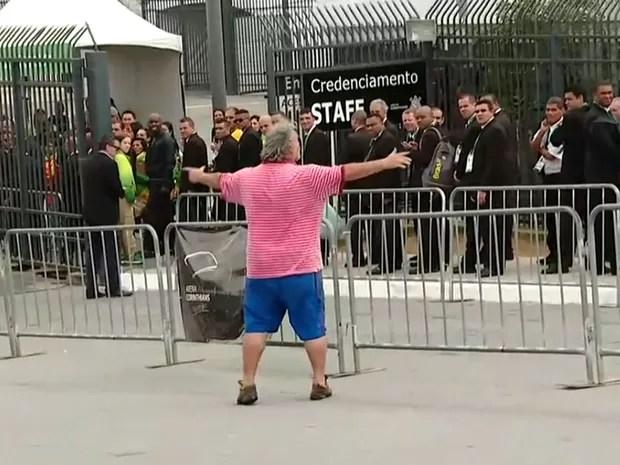 O homem começou a gritar com policiais na entrada do estádio e subiu em uma grade (Foto: TV Globo/Reprodução)
