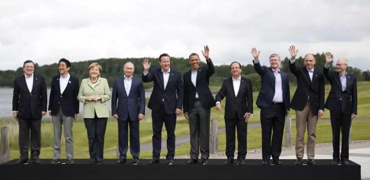 Merkel, a única mulher e única com roupa colorida, posa de verde em uma foto com líderes mundiais em uma reunião do G8 na Irlanda do Norte em 2013. — Foto: Matt Dunham/AP