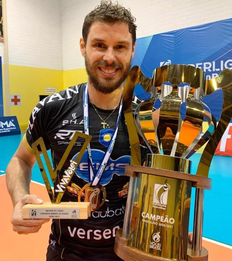 Bruninho, levantador do Taubaté, com o título da Superliga e o troféu Viva Vôlei — Foto: Divulgação/EMS Taubaté Funvic