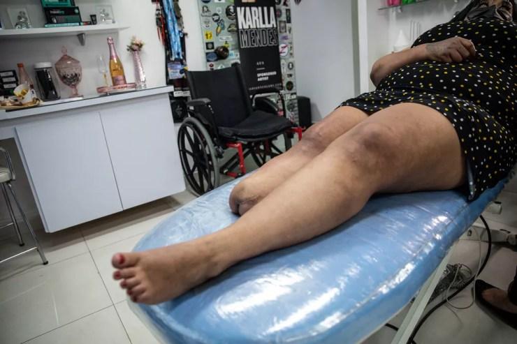Joseane é tatuada ao lado de sua cadeira de rodas. Espera por próteses do SUS, segundo ela, pode passar de 10 anos — Foto: Fábio Tito/g1