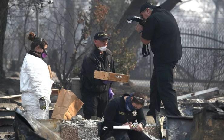 Policial fotografa uma caixa com pequenos ossos humanos — Foto: Justin Sullivan / Getty Images / AFP Photo