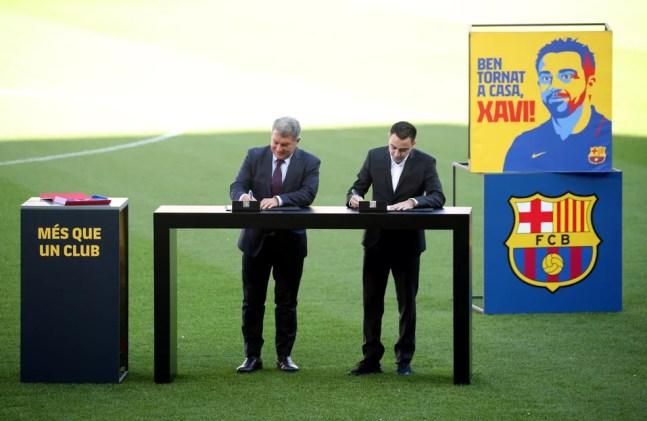 Xavi Hernández assinou contrato ao lado de Joan Laporta — Foto: Reuters